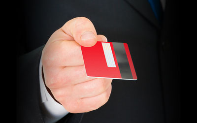 a man in suit holding a credit card